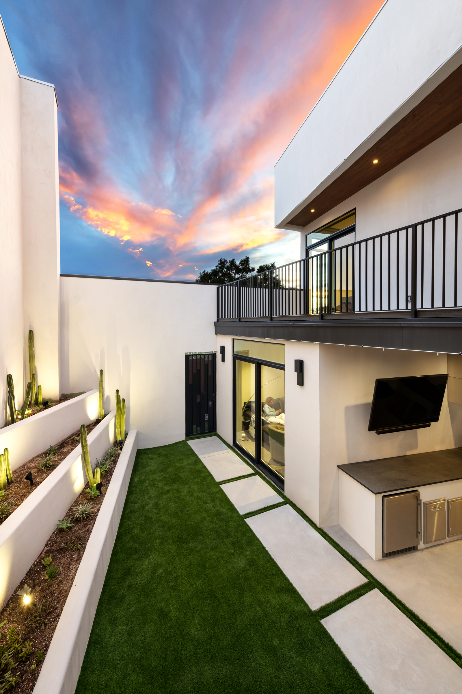 A narrow courtyard between warm masonry walls in a RAS Architecture home